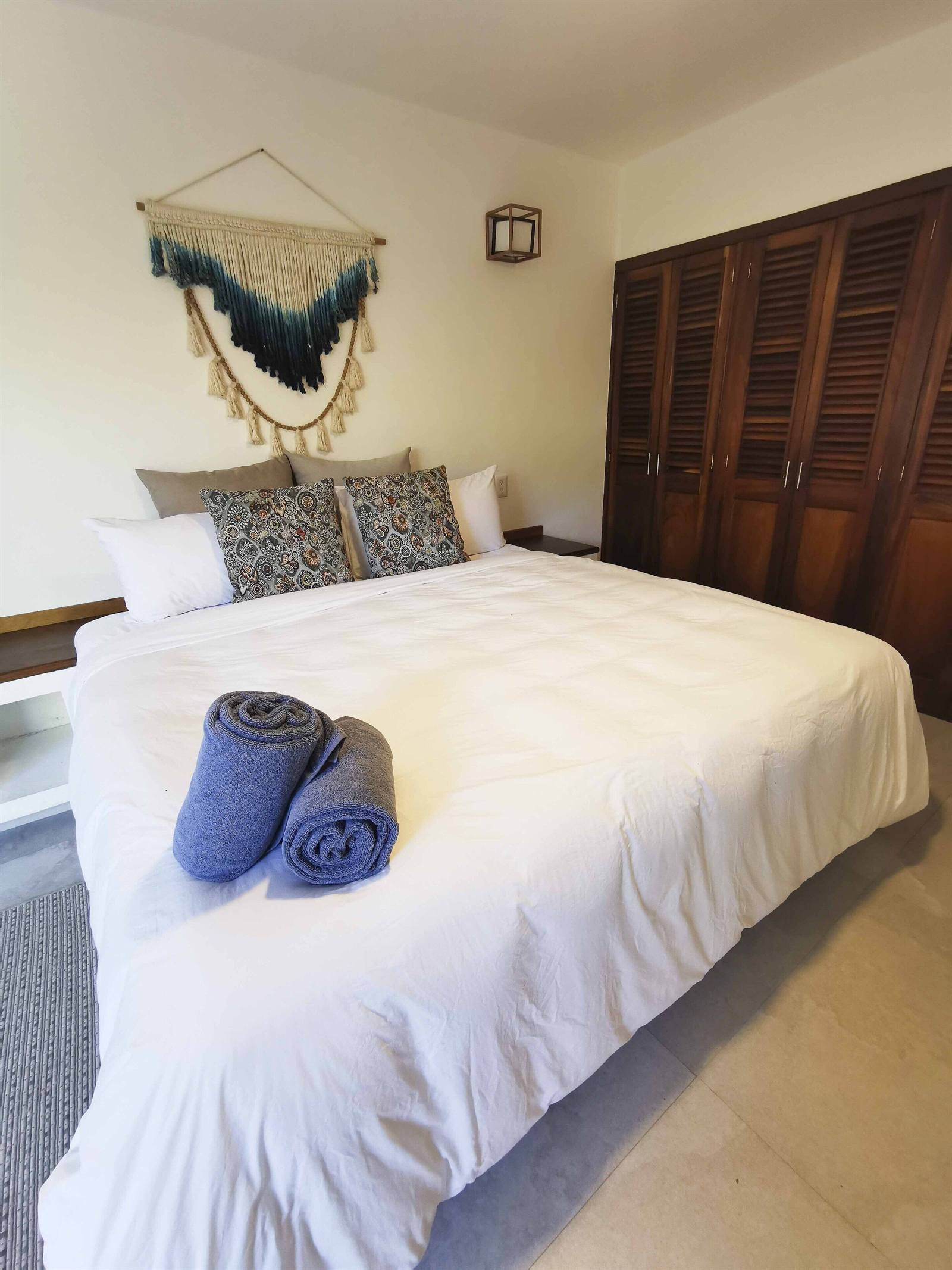 Casa Di Giulio: freshly made bed with rolled towels and a macramé hanging